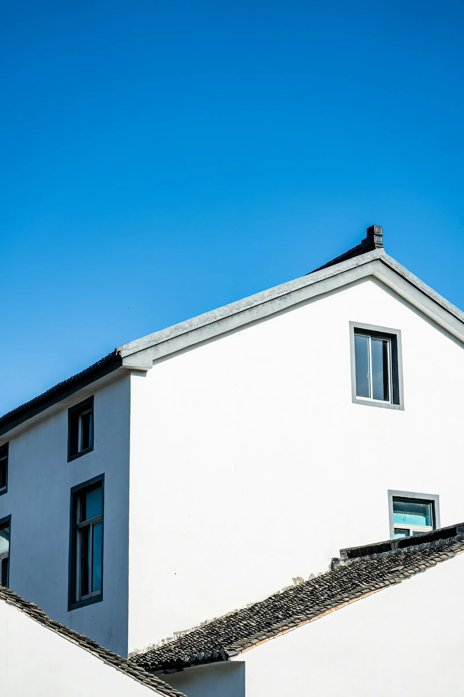 White rendered gable wall against a blue sky