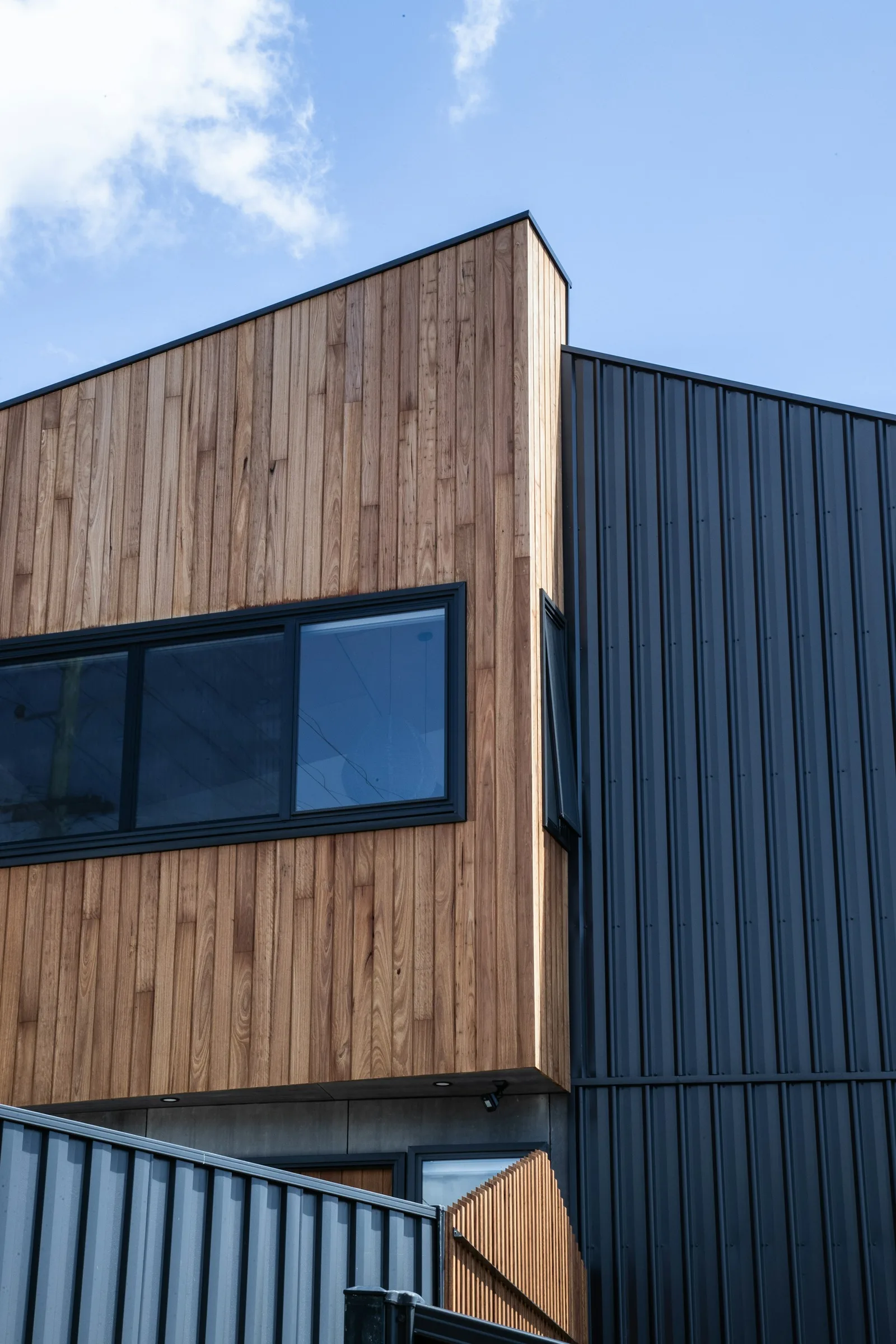 Modern facade where vertical cladding meets timber-look panels