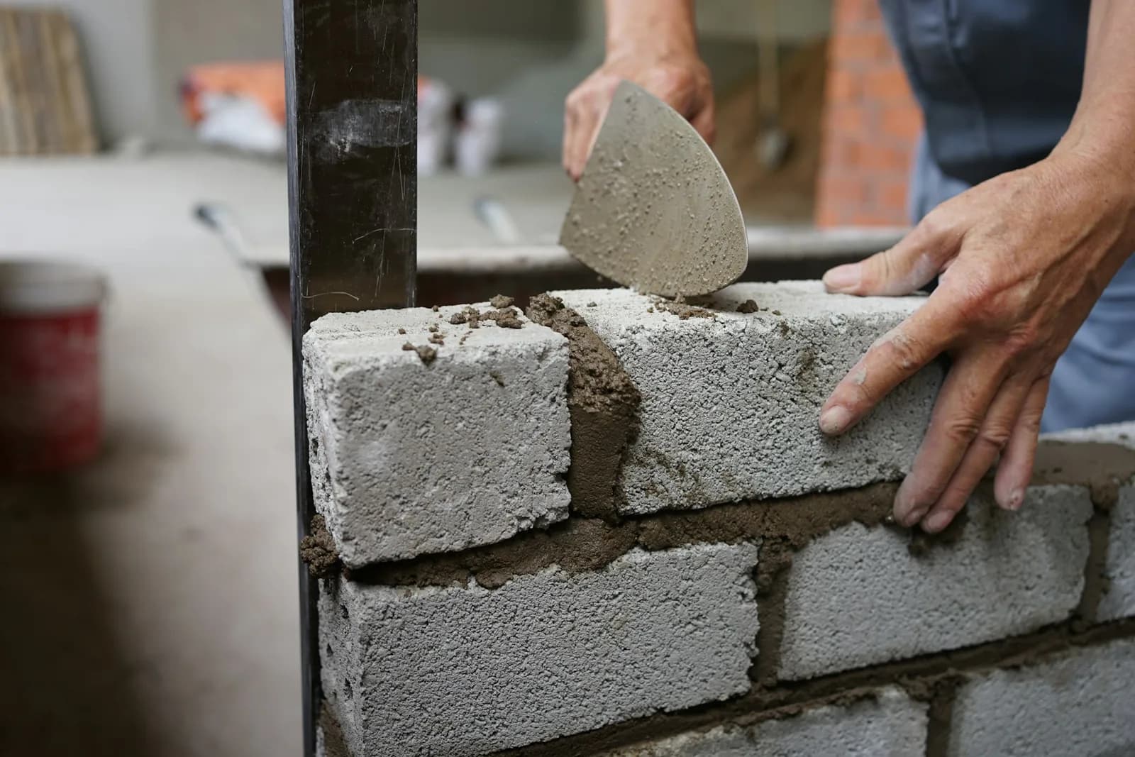 Tradesperson laying and mortaring blocks