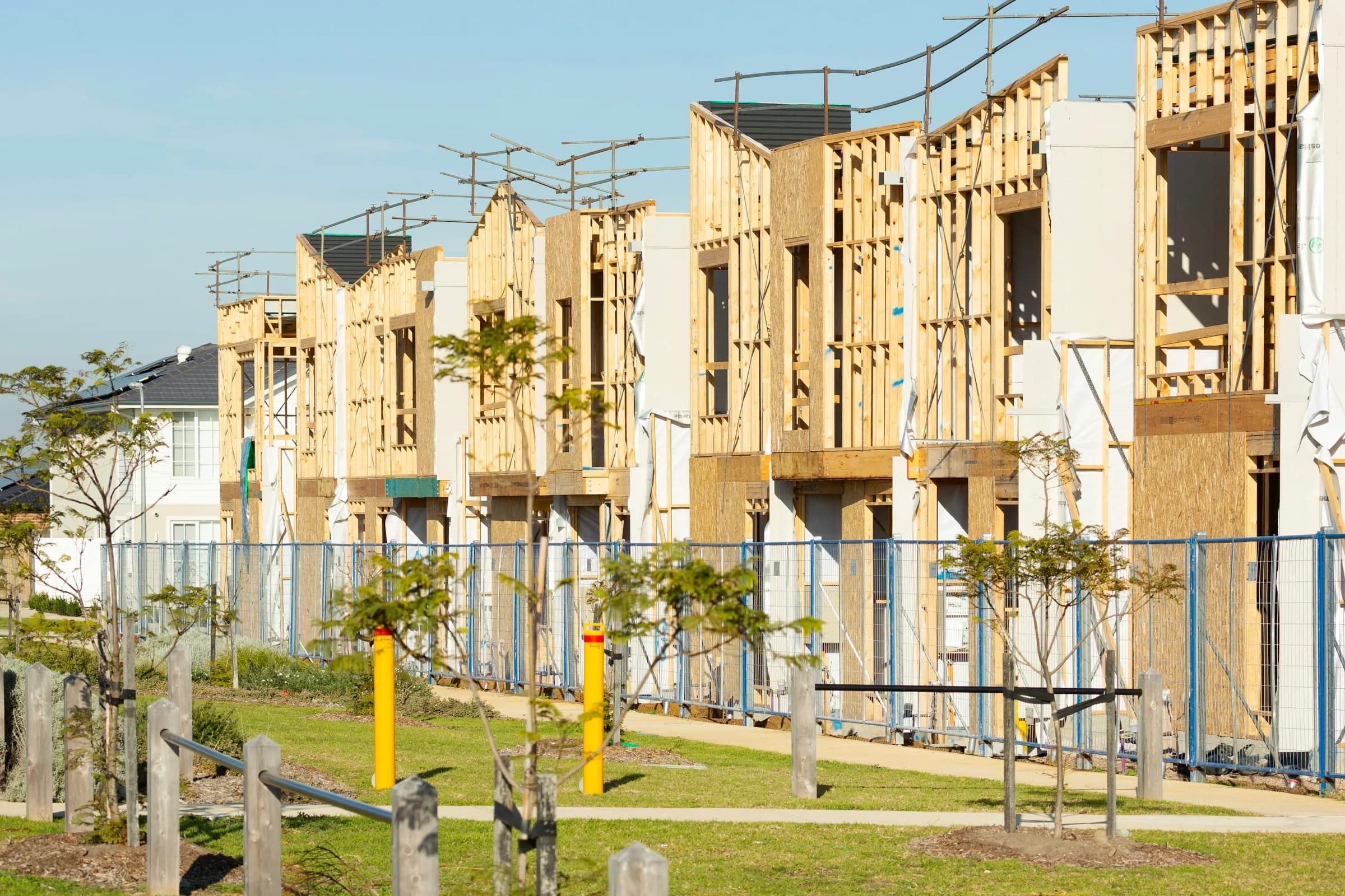 Homes under construction with timber frames and scaffolding in Clyde North, Victoria